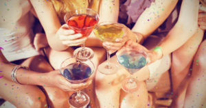 picture of girls toasting with colored cocktails